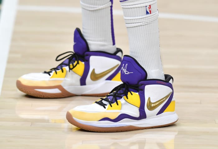 View of white, purple, and gold Nike Kyrie shoes.